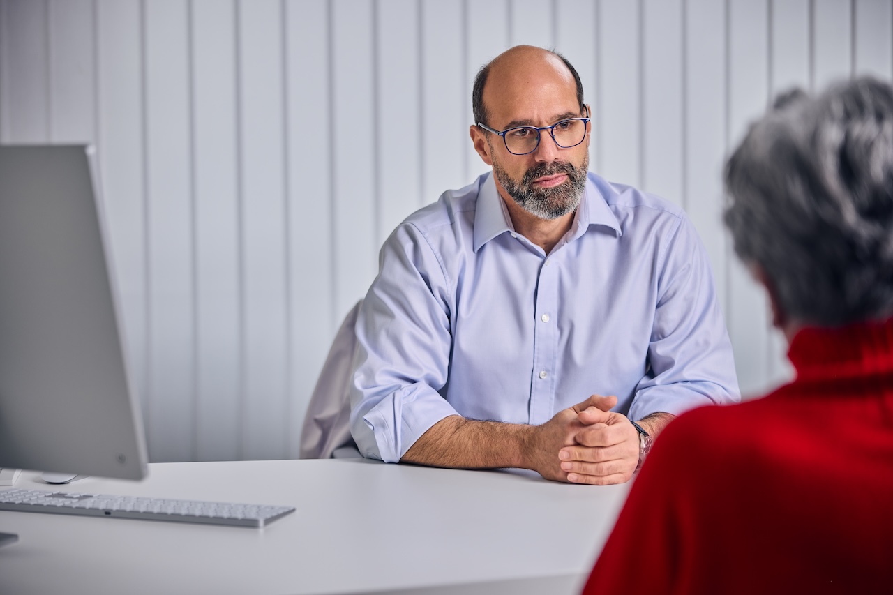 Orthopaede spricht mit dem Patienten.