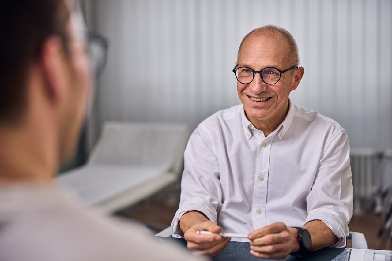 Neurologe spricht mit dem Patienten.